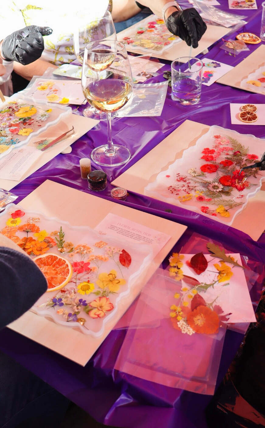 Group of friends making DIY resin trays together with wine